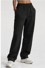 Model wearing black wide leg trousers with white trainers