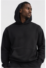 Model wearing a black pullover hoodie with the hood up
