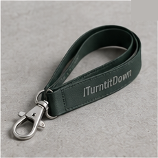 Tech Lanyard in forest with a metal clip and the ITurntItDown wordmark, on concrete